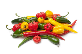 A collection of habanero, jalapeño, serrano, and ghost peppers, showcasing their diverse shapes and colors.
